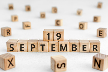 September 19 - from wooden blocks with letters, important date concept, white background random letters around