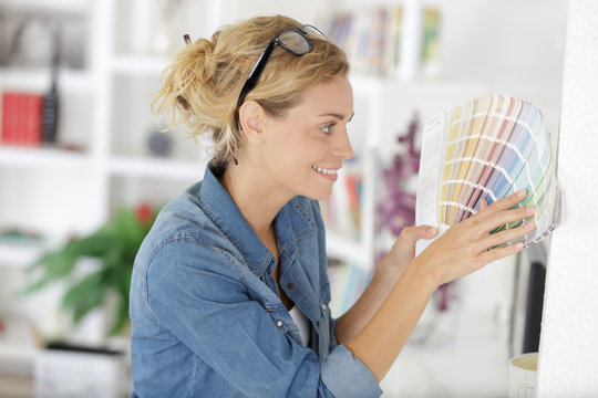 woman in the home looking at colour charts