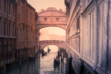 Gondolas row down canal towards bridge of sighs in Venice