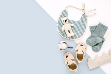 Bib,  socks, toy and cute baby slippers for boy.  Set of  newborn clothes and accessories. Flat lay, top view