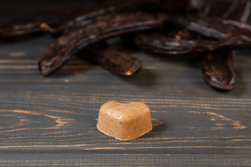 Healthy raw vegan sweet homemade candy on a wooden table background with carob