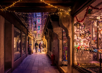 alley in venice with the warm yellow glow of christmas lights © C A Creative