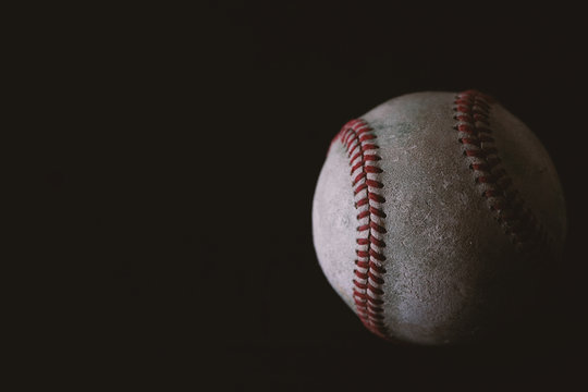 baseball on black background closeup, copy space by old used vintage ball