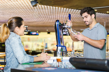 woman buying beer at the bar counter