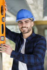 cheerful worker holdig a builders level