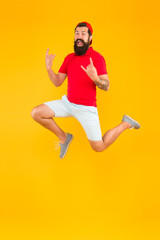 Fototapeta na wymiar Energy charge. Healthy guy feeling good. Inspired concept. Always in motion. Enjoying active lifestyle. Happy guy jumping. Active bearded man in motion yellow background. Active and energetic hipster