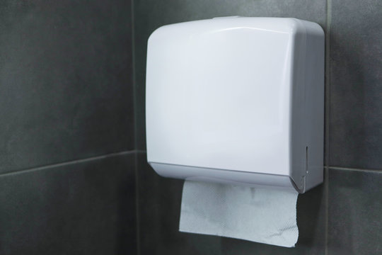 Box with paper towels for drying hands on a gray wall