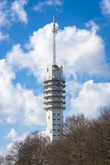 Communication tower in Alphen aan den Rijn, Netherlands with bright cumulus clouds in the background