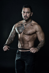 He got perfect torso. muscular man hold leather belt. fetish. bdsm love game. Sportsman bare chest and belly. Sport and fitness. Masculinity and brutality. handsome bodybuilder. Rocker or punk
