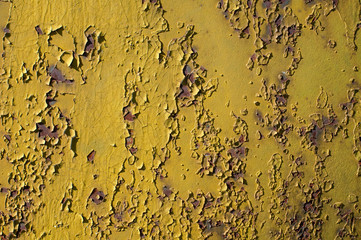 Background. Rusty metal surface. The yellow paint was peeling. The iron is oxidized. Cracks and fractures.