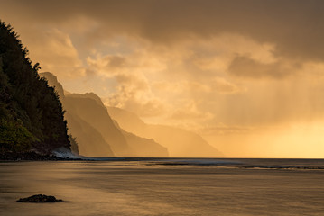 Sunset lights the receding cliffs of the NaPali coastline on north coast of Kauai in Hawaii - obrazy, fototapety, plakaty