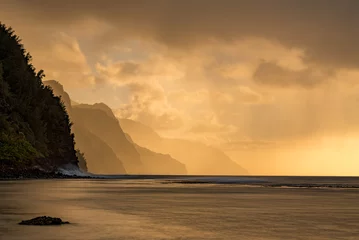 Poster Sunset lights the receding cliffs of the NaPali coastline on north coast of Kauai in Hawaii © steheap