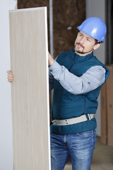 worker moving boards within residential construction site