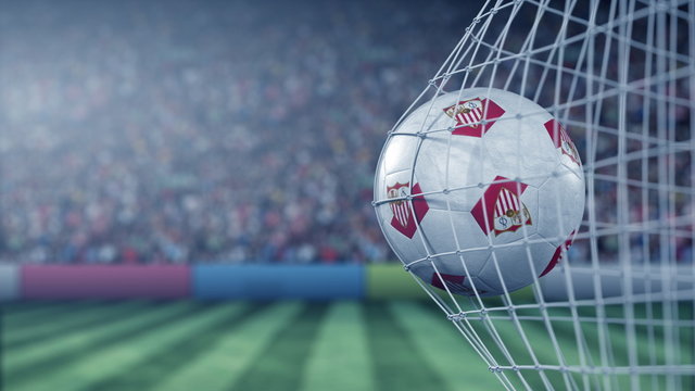 Sevilla FC football club logo on the ball in football net. Editorial conceptual 3D rendering