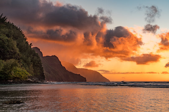 Sunset lights the receding cliffs of the NaPali coastline on north coast of Kauai in Hawaii - Powered by Adobe
