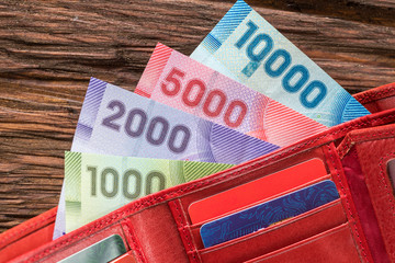 Obraz premium Chile money in the wallet on the wooden table top.