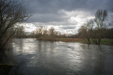 View over a river with high water in a snowless winter.