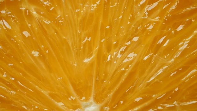 Rotating fresh yellow organic orange slice in extreme close up macro