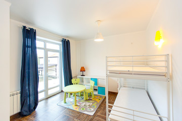 Children's room in the cottage. Bunk bed, window with blue curtains, large wardrobe with yellow...