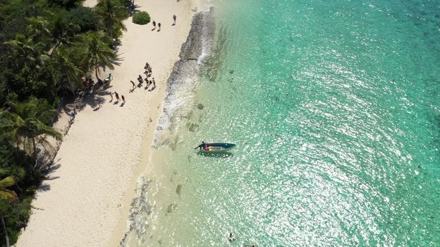 Aerial footage of drone over a small boat on beach clear blue waters in Mystery Island, New Caledonia