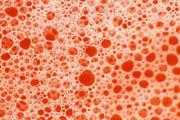 Foam close-up bubbles on a bright orange background. Orange soap foam macro background. Soap bubbles orange  color with a white gradient. Bath foam. Cleanliness and order.