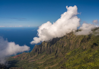 Fluted rocks of the Na Pali mountains with clouds forming over the peaks from Kalalau lookout on Kauai