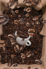 white coffee cup lies in roasted coffee beans of the highest standard