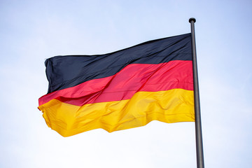 Germany flag waving in the wind close-up against a blue sky
