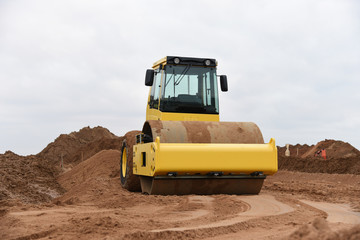 Vibration single-cylinder road roller leveling the ground for the foundation. Soil Compactor for laying asphalt on road at construction site. Road compaction equipment