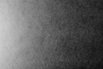 Black and white background made of real black paper with white dots, illuminated by a soft light from the left.