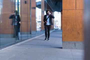 Portrait Of young Businessman  Outside Office. Meeting Concept. Man Walking and drinking coffe, going to the office.