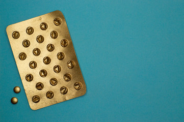 empty blister pack and little pills on blue background