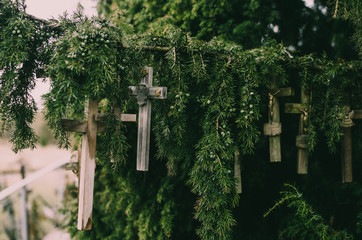 Wooden crosses hanging on the branches of a gree fir
