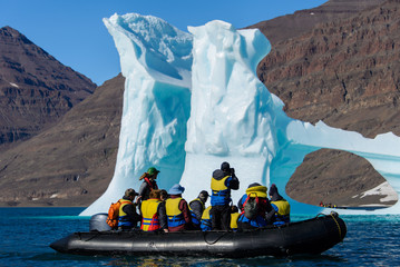 Landscape with iceberg in Greenland at summer time. Sunny weather. Inflatable boat with tourists. © Alexey Seafarer