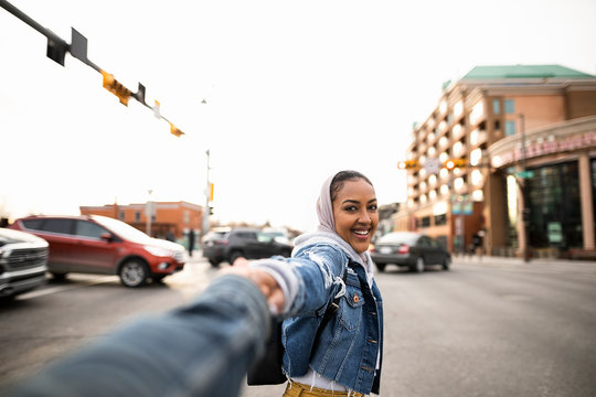 Personal perspective young woman holding hands with boyfriend on city 