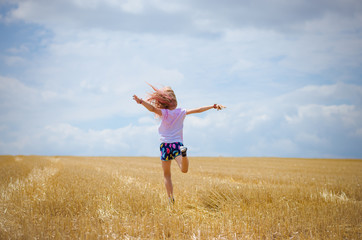 Fototapeta premium little child having fun in agricultural field backview