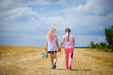children walking in golden fields together hand in hand