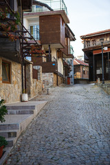 Cobblestone and stone-tiled streets of the old tourist part of the city of Bulgaria. Typical Bulgarian houses made of stone and wood in old Sozopol, Nessebar, Veliko Tarnovo