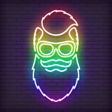 A neon sign in the form of a hipster with a beard, glasses and an iroquois. Shimmering all the colors of the rainbow. Against the background of a brick wall, with a shadow.