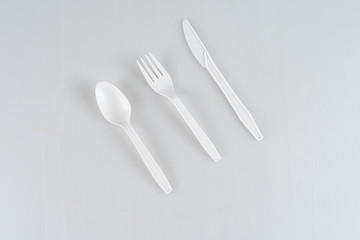 White, plastic, disposable spoon, fork and knife isolated on a white background.