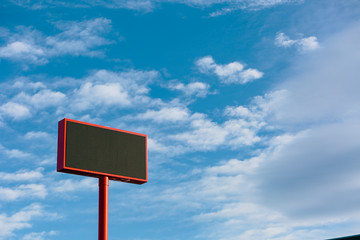large advertising banner over blue sky with clouds, with the center cut to place your advertising