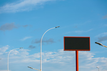 large advertising banner over blue sky with clouds, with the center cut to place your advertising
