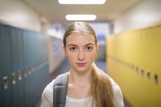 Portrait confident junior high girl student in corridor