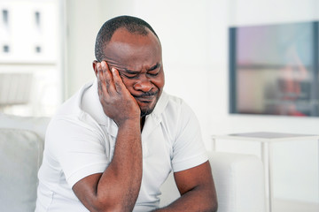 Sad face depressed elderly african man. Very sad elderly man. Portrait of a sad elderly man close-up. Lonely african elderly man is sad sitting on the bed at home. Male feel depression.      