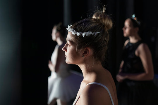 Curious young female ballerina watching off stage