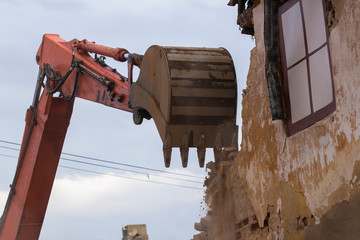 Building demolition. Construction machinery demolishes an old building