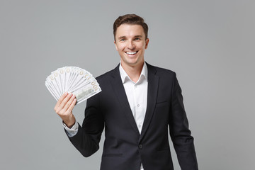 Smiling young business man in classic black suit shirt posing isolated on grey background....