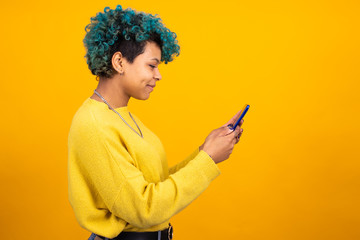 girl or woman looking at mobile phone isolated in color background