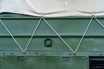 side of a dark green military truck with an awning