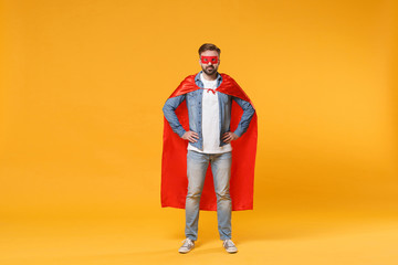 Bearded young man in casual denim clothes, Super hero costume posing isolated on yellow orange background studio portrait. Love family parenthood childhood concept. Standing with arms akimbo on waist.